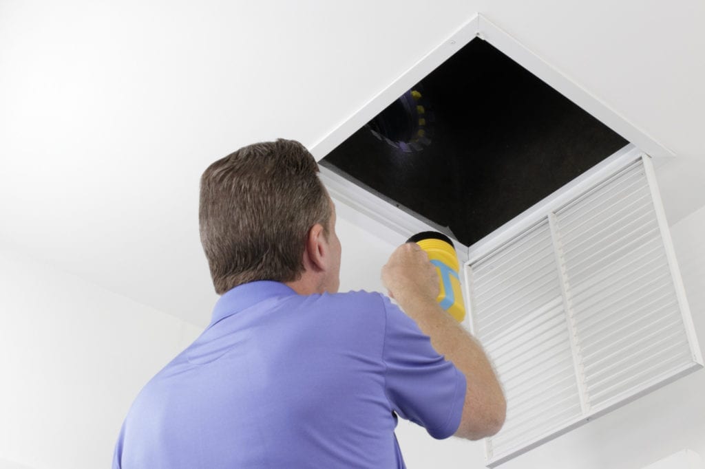 examining HVAC ducts in a large square vent