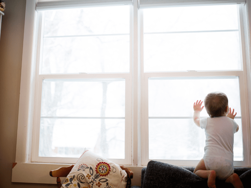 toddler at double hung windows